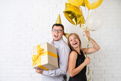 Portrait of a smiling young woman holding balloons