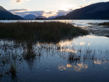 Scenic view of lake against sky at sunset