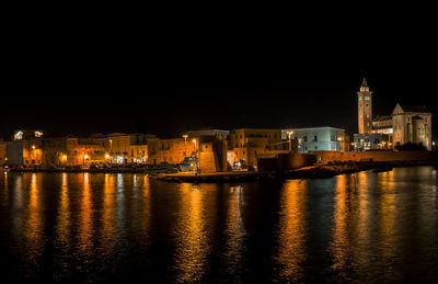 Illuminated buildings at waterfront. trani, italy