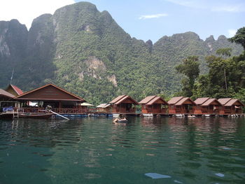 Stilt houses in mountains against sky