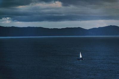 Sailboat sailing on sea against sky