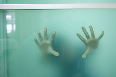 Cropped hands seen through glass