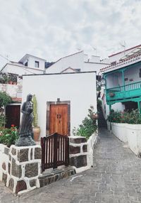 Statue outside house against sky