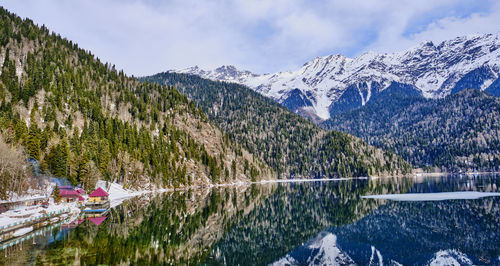 Scenic view of lake by snowcapped mountains against sky