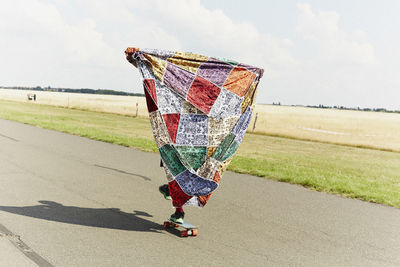 Close-up of person on road against sky