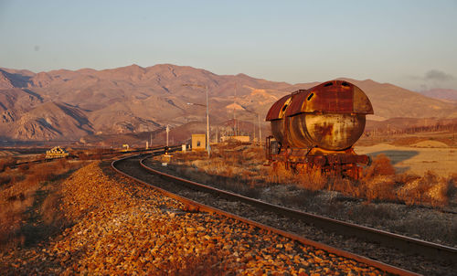 Railroad tracks in desert against clear sky