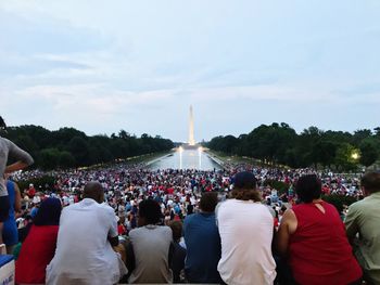 Crowd against illuminated washington monument at dusk
