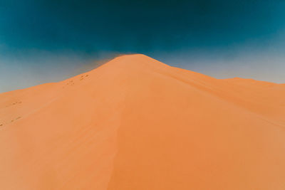 Scenic view of desert against blue sky