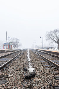 Railroad tracks against clear sky during winter