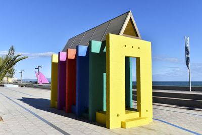 Multi colored built structure against clear blue sky