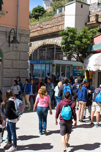 People walking on street against buildings in city