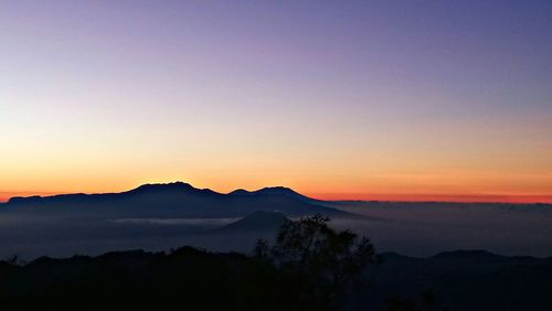 Scenic view of silhouette mountains against sky at sunset