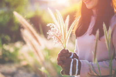 Midsection of woman with pink flowering plants