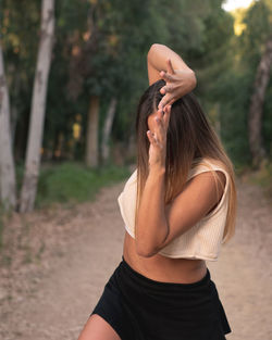 Midsection of woman standing by tree