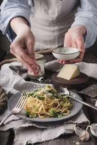 Midsection of woman preparing pasta with brussels sprout 