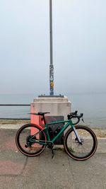 Bicycles on road by sea against sky