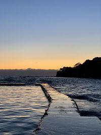 Scenic view of sea against clear sky during sunset