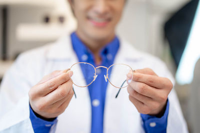 Midsection of doctor holding dentures