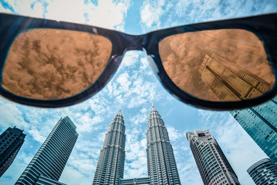 Low angle view of sunglasses against modern buildings in city