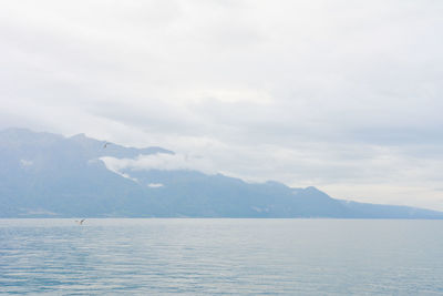 Scenic view of sea and mountains against sky