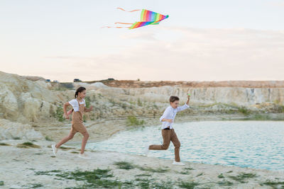 Teenagers run with a kite outdoor activity a day off.