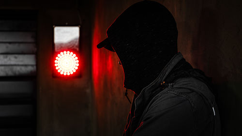 Portrait of person in illuminated red light painting