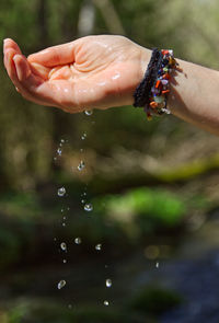 Close-up of hand holding water drops