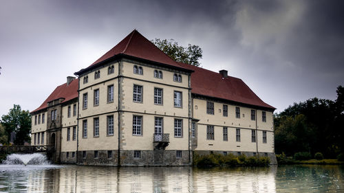 Building by river against sky