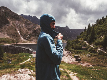 Side view of a woman looking at mountain against sky