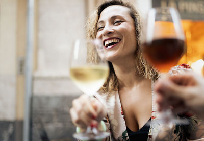 Close-up of a smiling young woman drinking glass