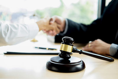 Midsection of man holding wine glass on table