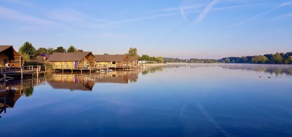 Reflection of building on lake against sky