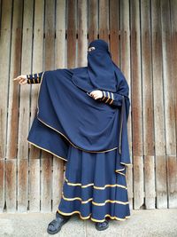 Rear view of person standing against blue wall