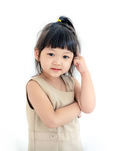 Portrait of cute girl standing against white background