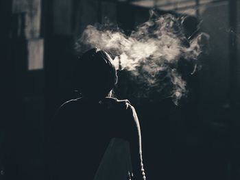 Rear view of man smoking at home