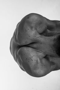 High angle view of shirtless man sitting on white background