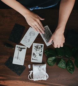 High angle view of man holding tarot cards on table