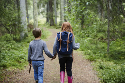Girl and boy walking in forest