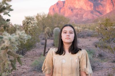 Portrait of teenage girl standing against plants