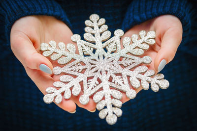 Midsection of woman holding snowflake