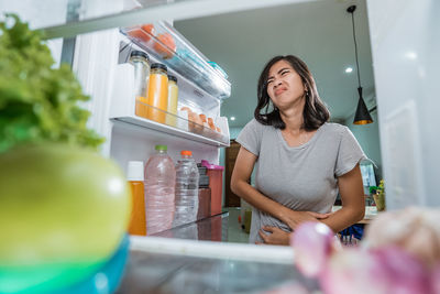 Young woman standing by bottles