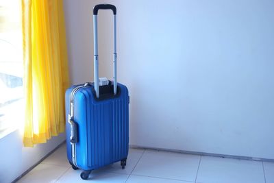 Blue metallic luggage in room