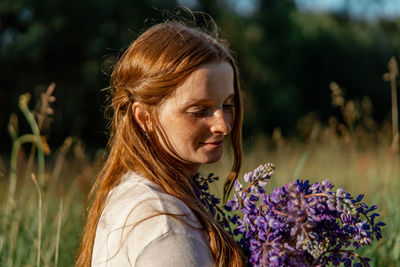 Close up portrait of young beautiful redhead woman with freckles, wearing white dress