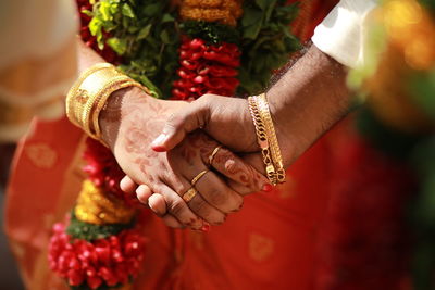 Midsection of couple holding hands