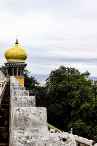 Exterior of temple by building against sky