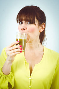 Portrait of young woman drinking drink