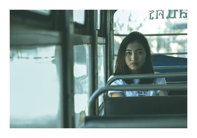 Portrait of young woman sitting in bus