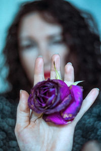 Close-up of woman holding purple flower