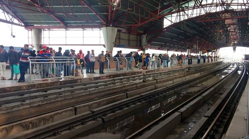 Group of people waiting at railroad station platform