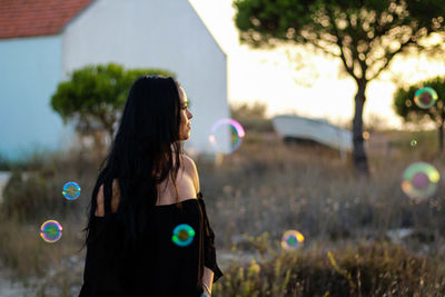 Young woman amidst bubbles in park